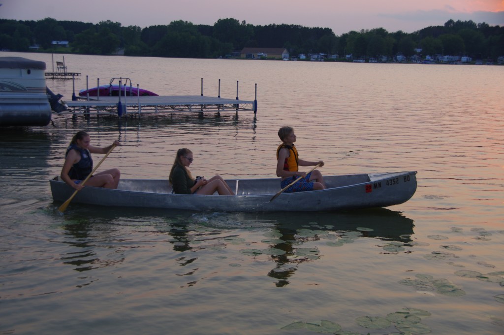 Kids in a canoe near sunset.