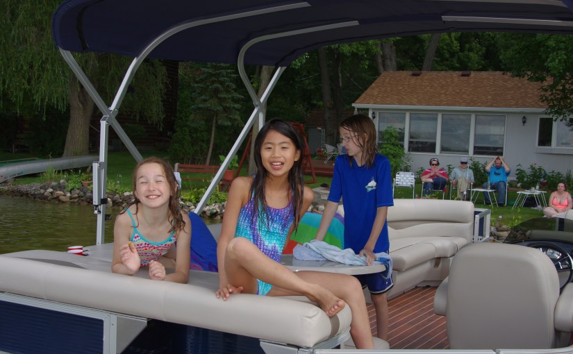 Kids sitting on the back of the pontoon.